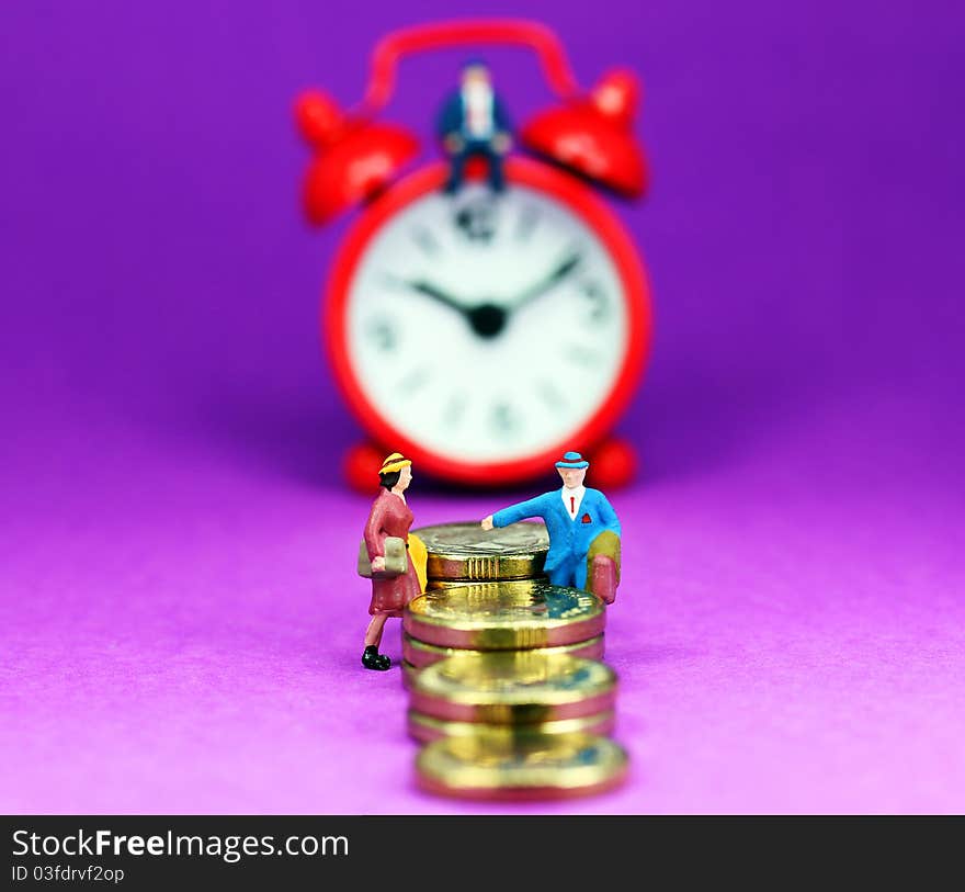 A couple on a gold coin stairway with a red alarm clock in the background with the bank manager sat on top of the clock and with a pastel purple background, asking the question how long before you will be free of the bank and its loan. A couple on a gold coin stairway with a red alarm clock in the background with the bank manager sat on top of the clock and with a pastel purple background, asking the question how long before you will be free of the bank and its loan