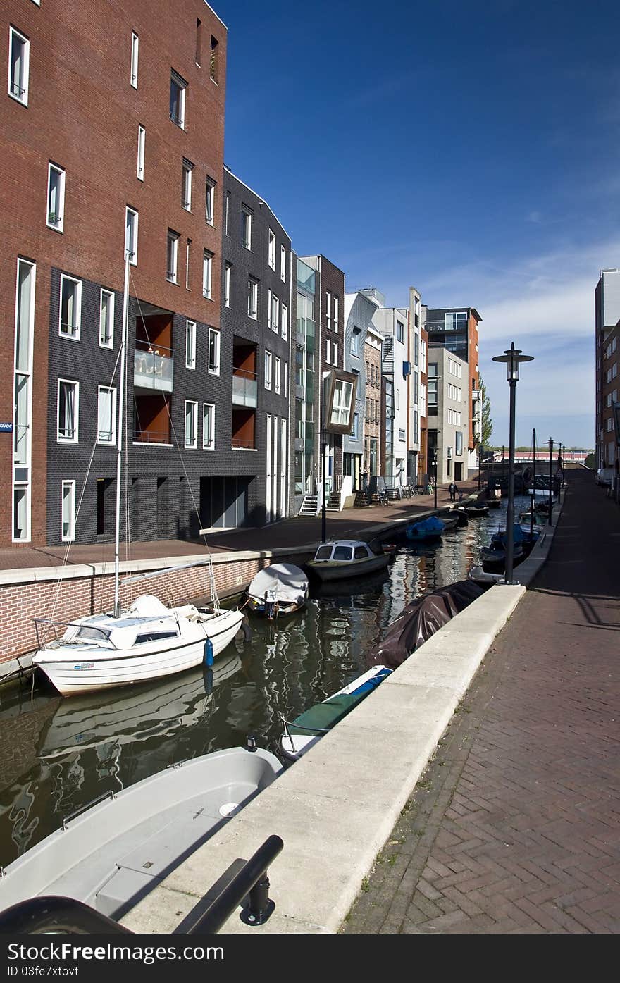 Modern residential houses on the canal in Amsterdam. Spring cityscape.