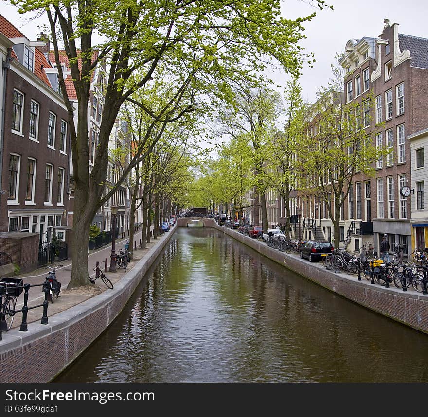 Canal in Amsterdam. Spring cityscape. Bicycles are on the waterfront.