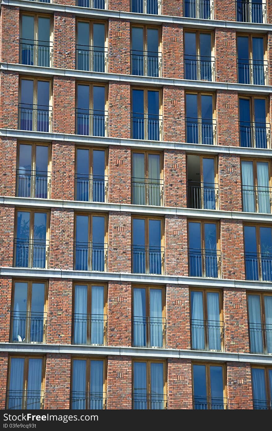 Fragment of the facade of the modern brick residential house with the same balcony. Detail.