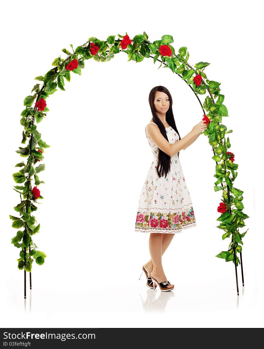 Picture of cute girl on the background of the arch entwined by roses. Picture of cute girl on the background of the arch entwined by roses