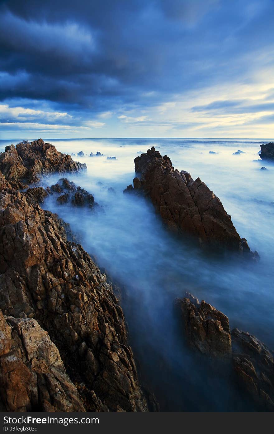 A long exposure showing the motion of the clouds and ocean over an extended period of time. A long exposure showing the motion of the clouds and ocean over an extended period of time.