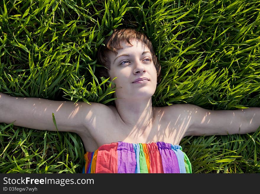 Young woman lying on grass, smiling