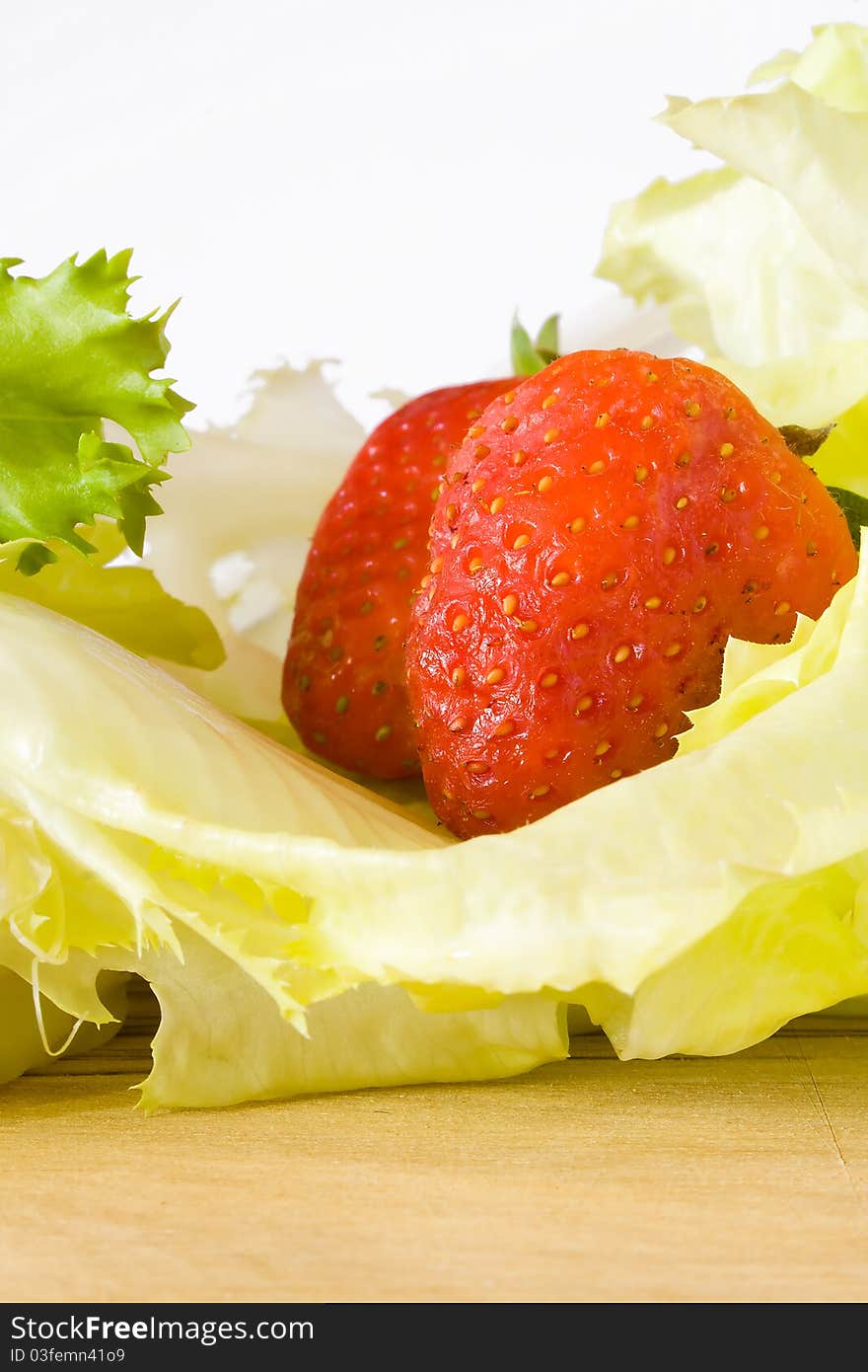 Closeup of strawberry above lettuce. Closeup of strawberry above lettuce