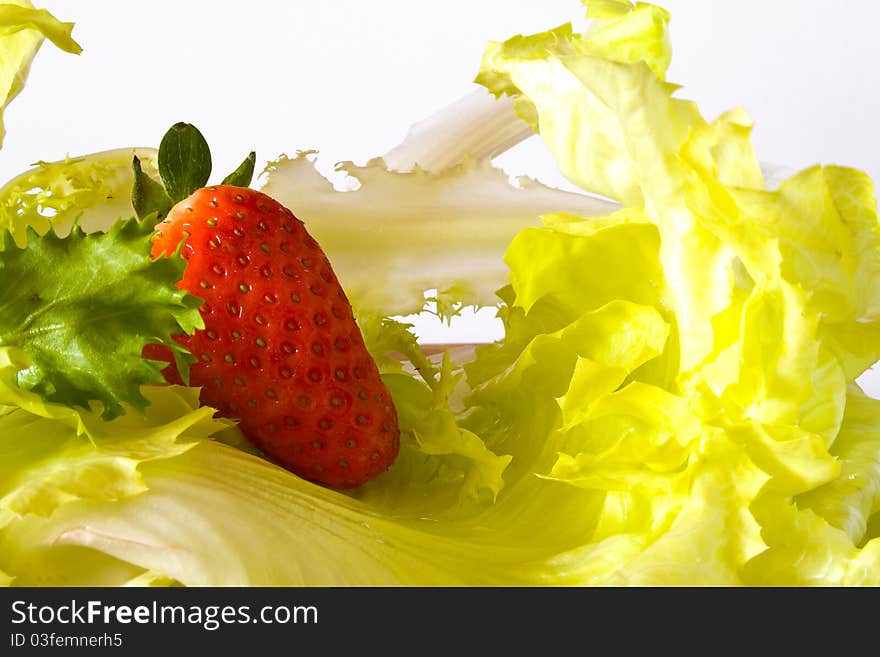 Closeup of strawberry above lettuce. Closeup of strawberry above lettuce