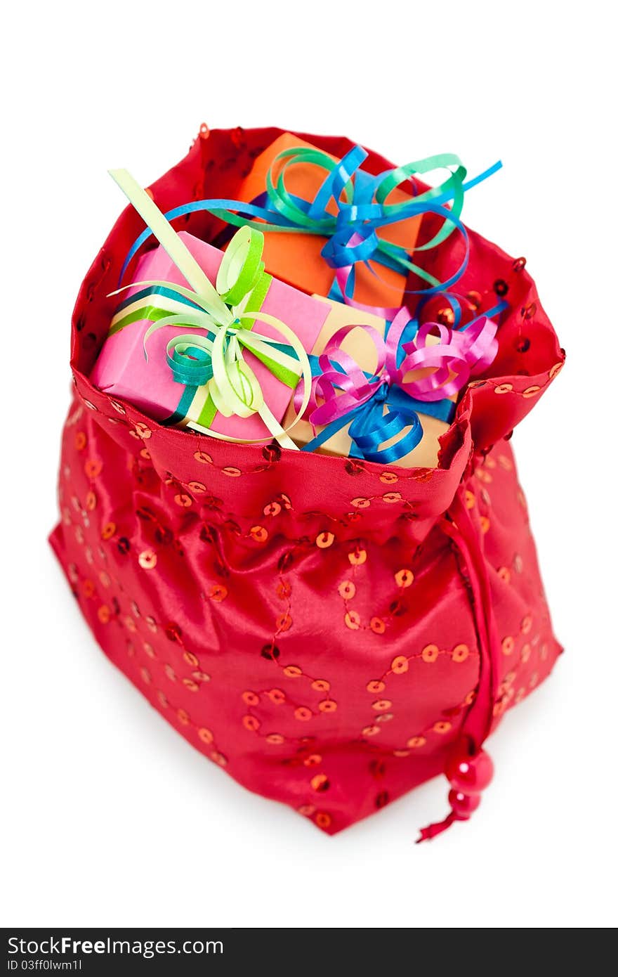 Colorful gift boxes with ribbons and bows in a red bag, isolated on white studio background. Colorful gift boxes with ribbons and bows in a red bag, isolated on white studio background