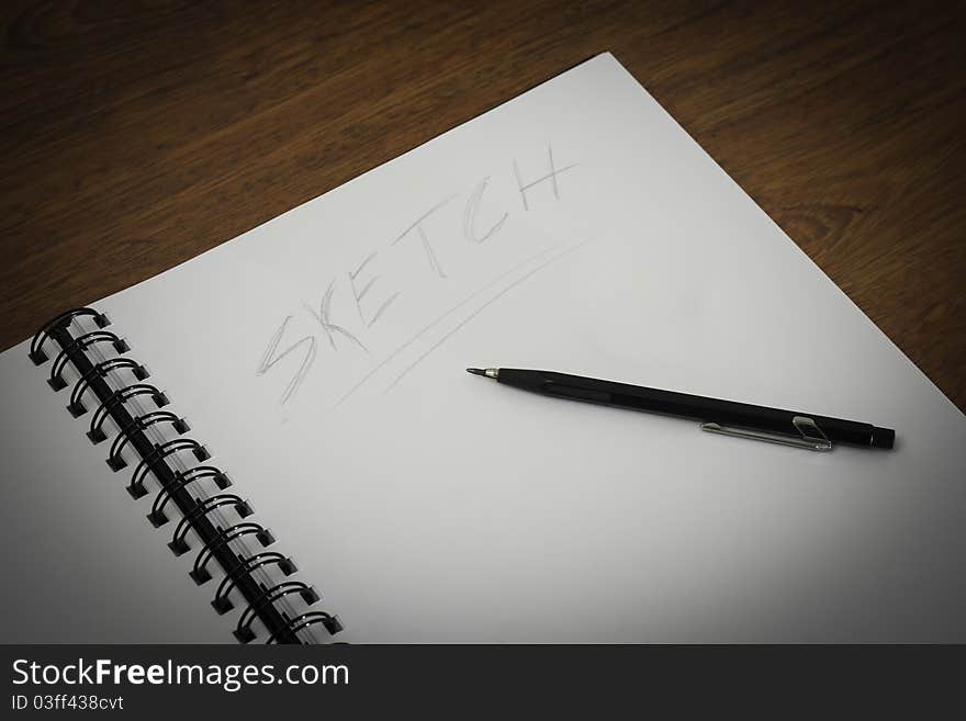 Wire notepad on a wooden desk background. Wire notepad on a wooden desk background