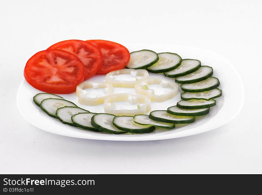 Fresh salad made of tomato, cucumber and paprika on white plate