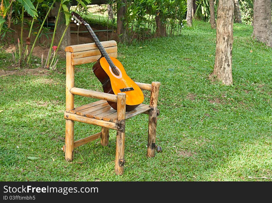 Acoustic Guitar on old rocking chair on grass