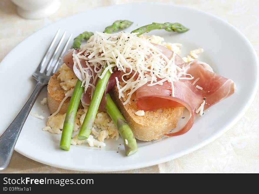 Roasted asparagus with scrambled egg and Parma ham on toast