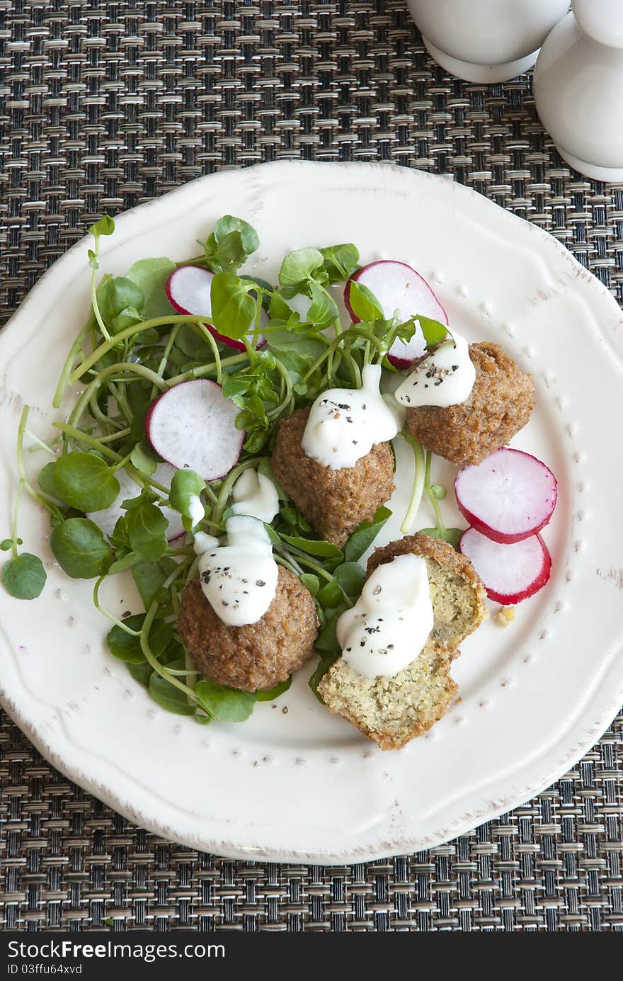 Falafels with radish and watercress on a plate