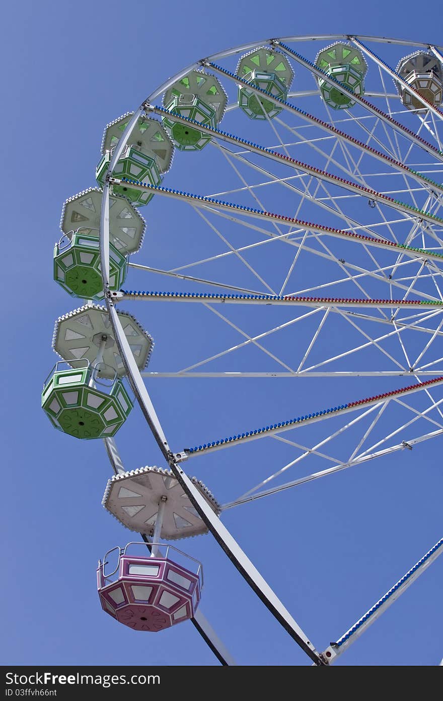 Close-up of big ferris wheel on blue sky background. Close-up of big ferris wheel on blue sky background