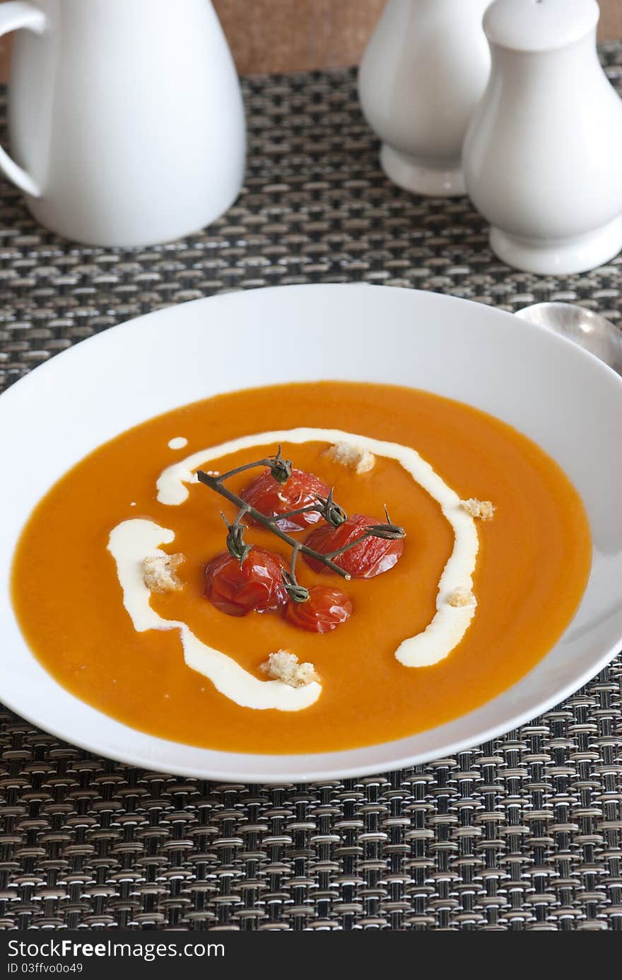 Cream of tomato soup with roasted vine tomatoes in a plate