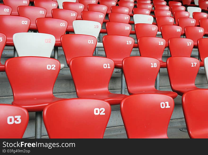 A red and white chair with number array in stadium. A red and white chair with number array in stadium.