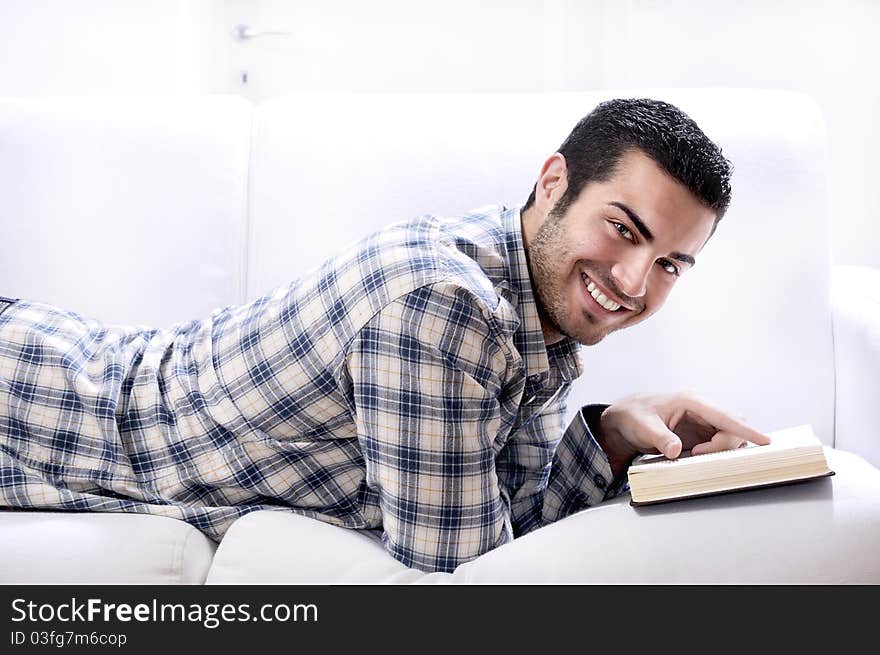 Young man reading book in home interior on white background