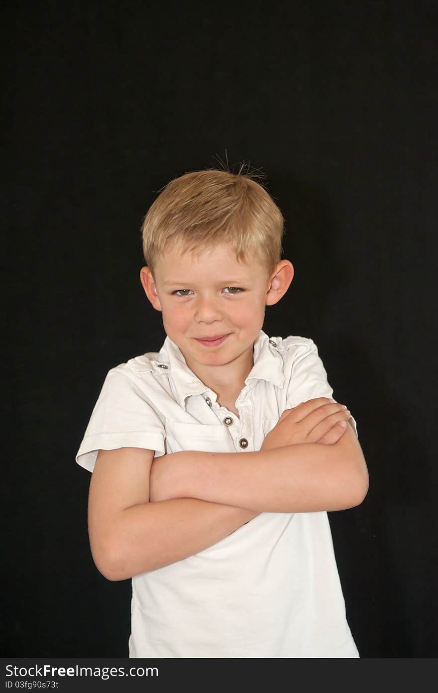 Adorable young boy with arms crossed isolated on a black background. Adorable young boy with arms crossed isolated on a black background