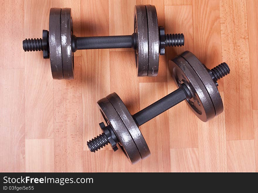 Two heavy dumbbells on a floor