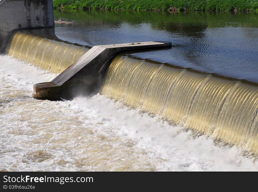 In most cases weirs take the form of a barrier across the river that causes water to pool behind the structure (not unlike a dam), but allows water to flow over the top.