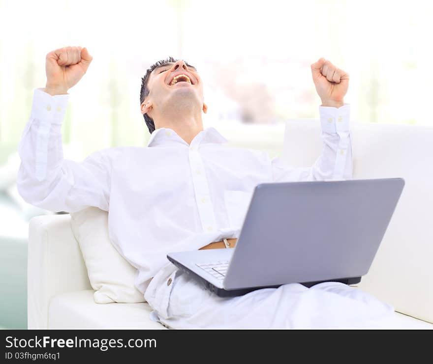 Portrait of a handsome young man looking upwards while using laptop