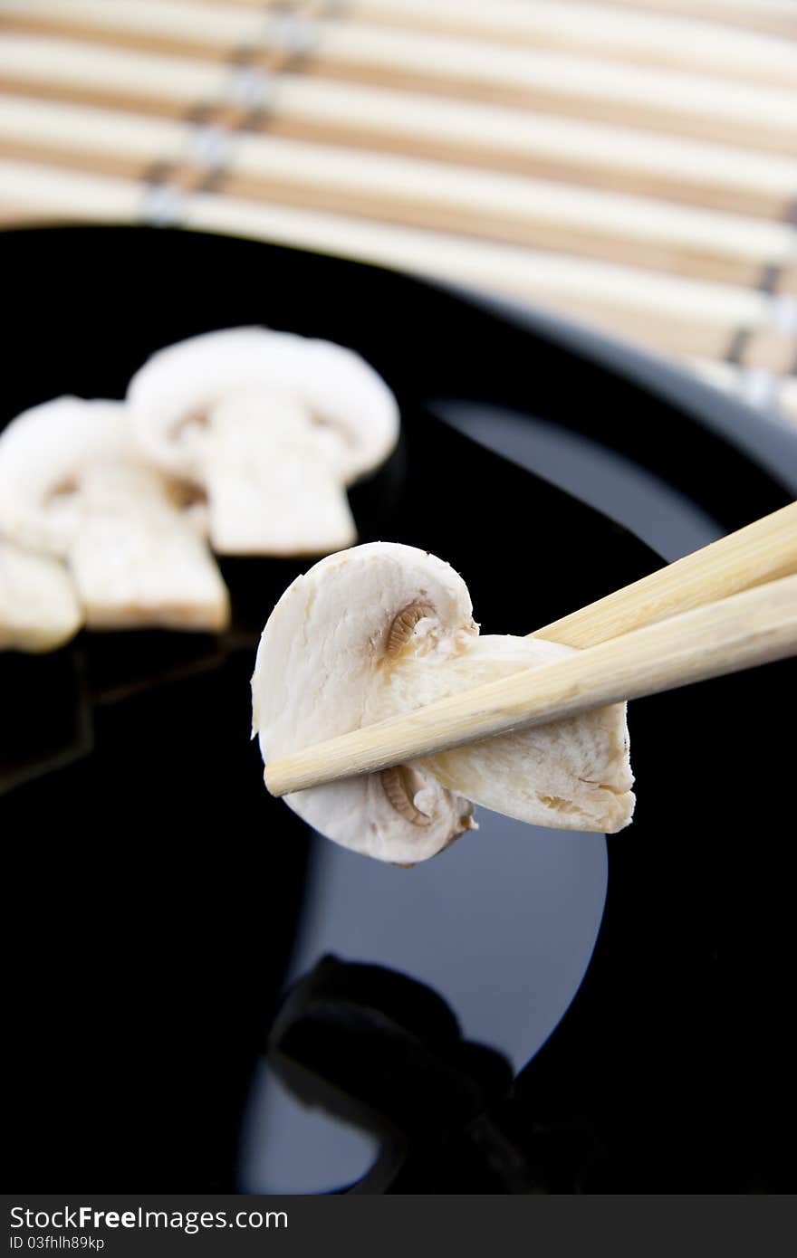 Holding Mushrooms with chopsitcks above a plate