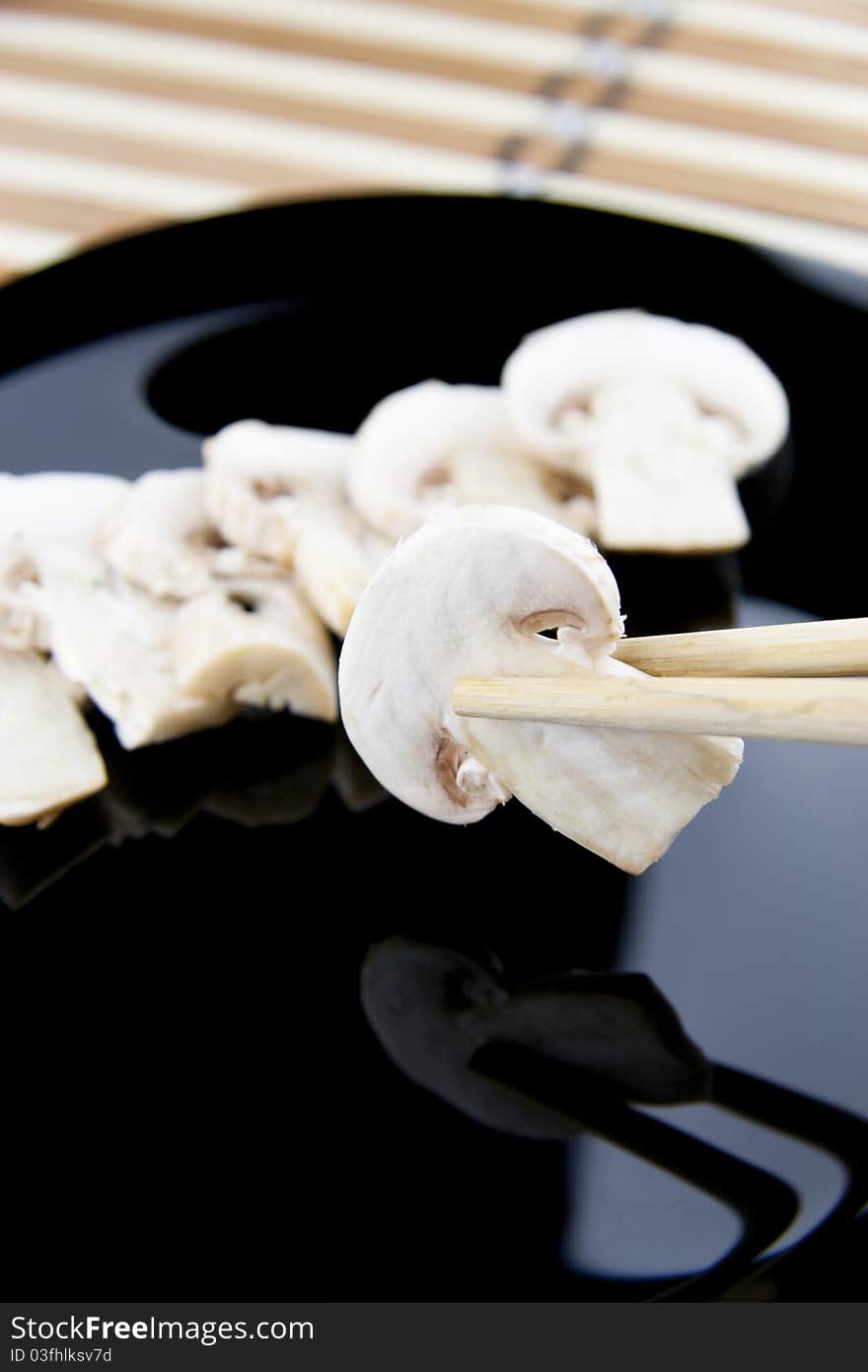 Holding Mushroom above black plate. Holding Mushroom above black plate