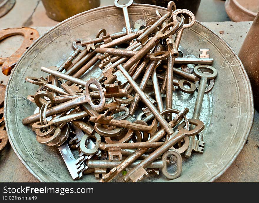 A lot of old brass key on an old plate