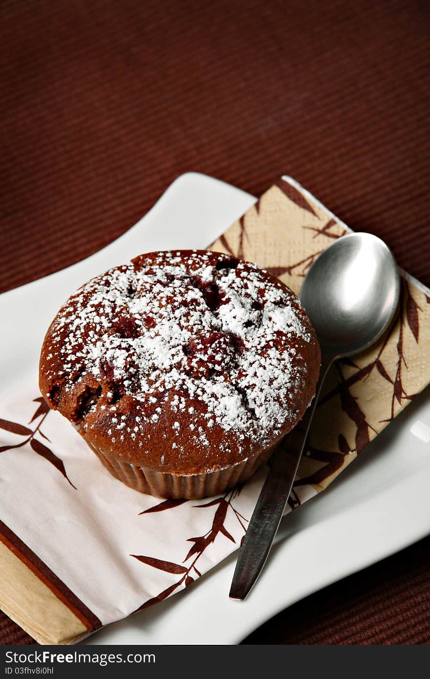 Chocolate muffin with cherries on ceramic plate. Chocolate muffin with cherries on ceramic plate