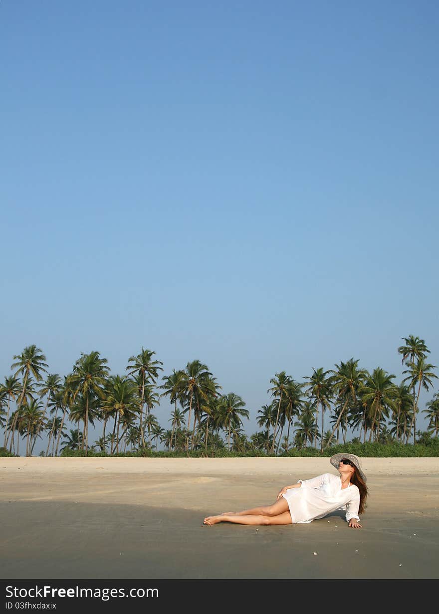 Woman in white hat lying on the beach in tropical country. Woman in white hat lying on the beach in tropical country