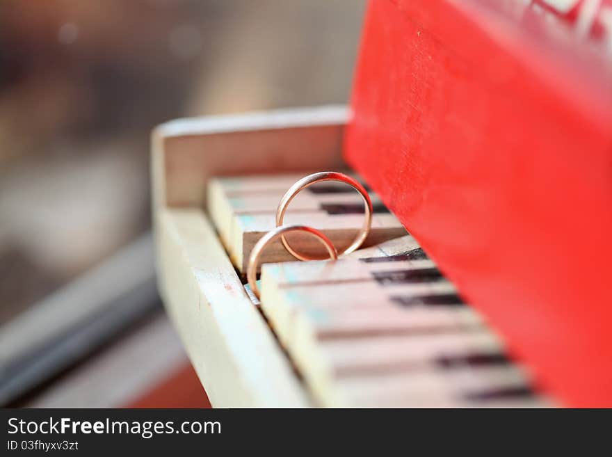 Classic golden wedding ring on the piano keys. Classic golden wedding ring on the piano keys