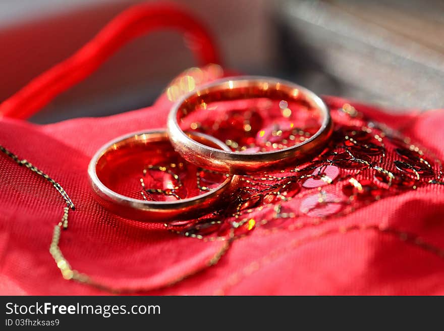 Wedding golden rings on the red silk material background. Wedding golden rings on the red silk material background