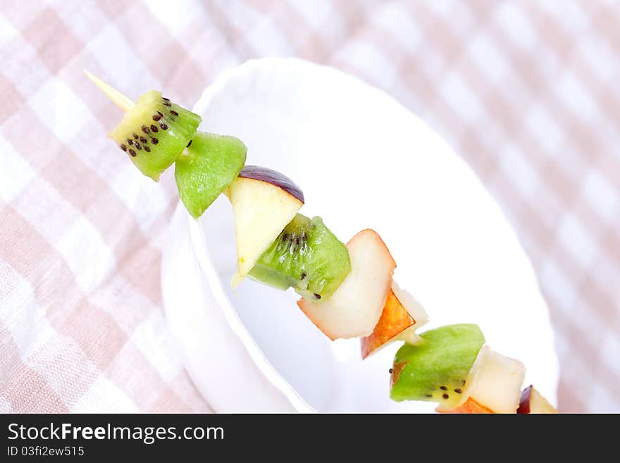 Fruit shashlik on white plate, closeup