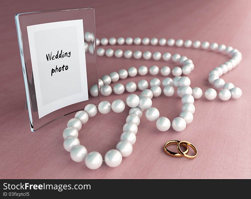 Glass frame on wood table with pearl beads and two rings. Glass frame on wood table with pearl beads and two rings