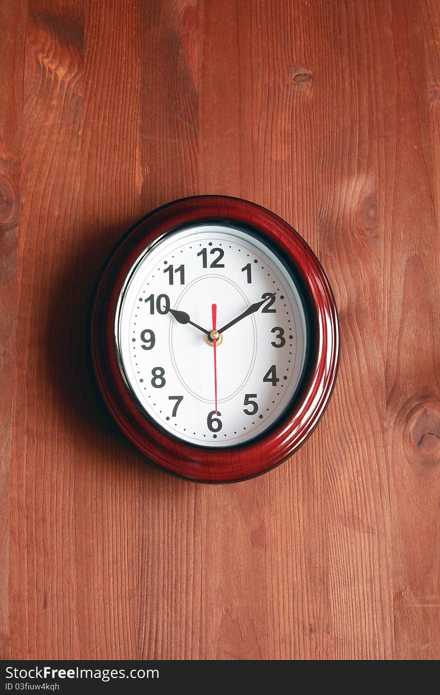 Nice modern clock hanging on wooden surface. Nice modern clock hanging on wooden surface