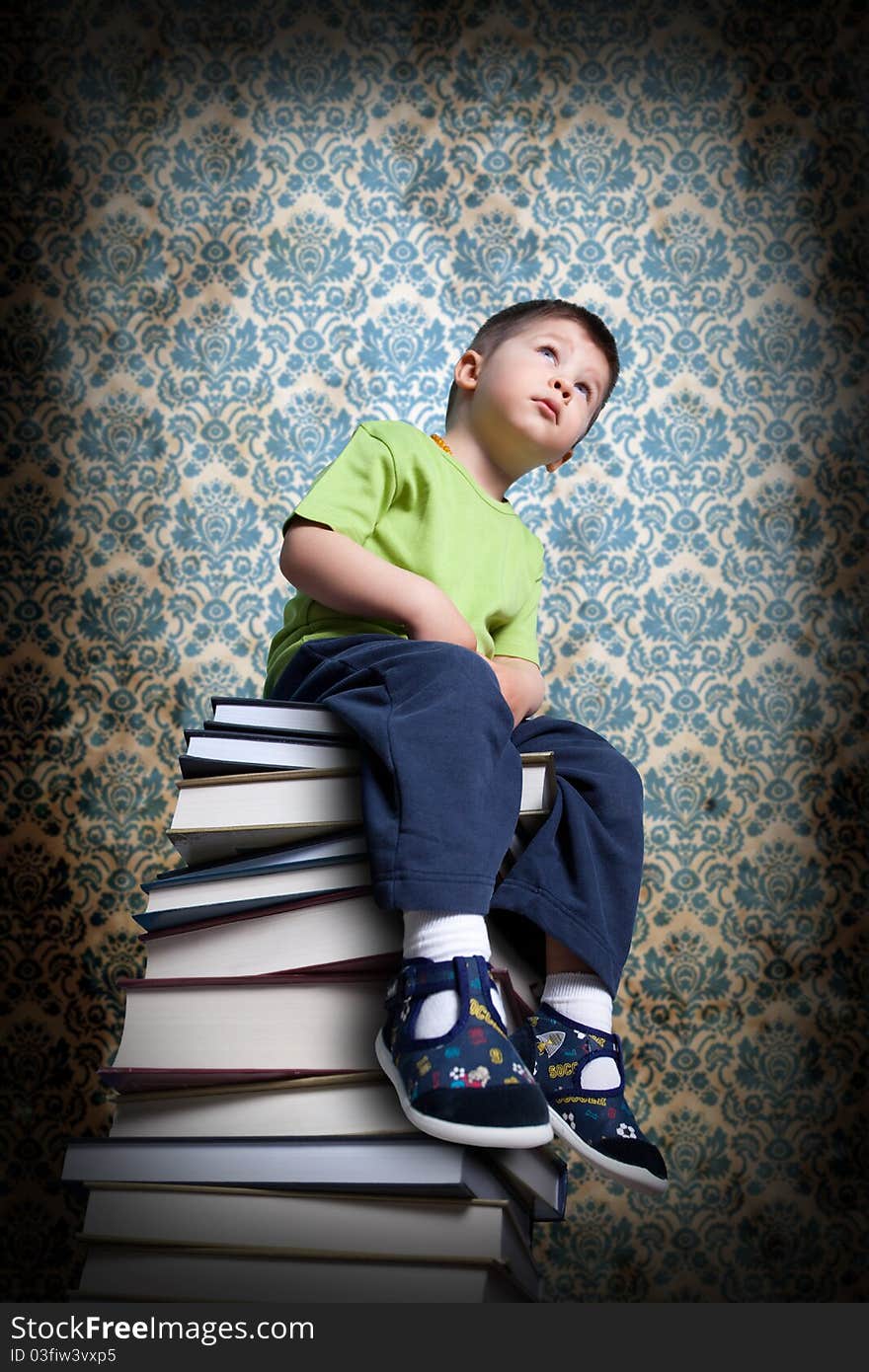 Small Boy Sitting On Books