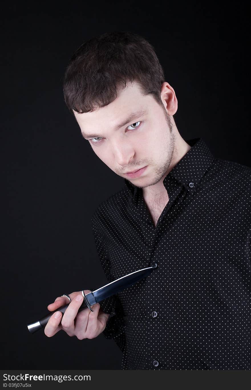 Portrait of depressive man with knife in black cloth. Portrait of depressive man with knife in black cloth