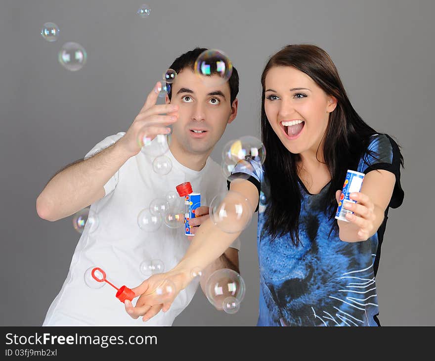 Pretty couple in love blowing bubbles and having fun