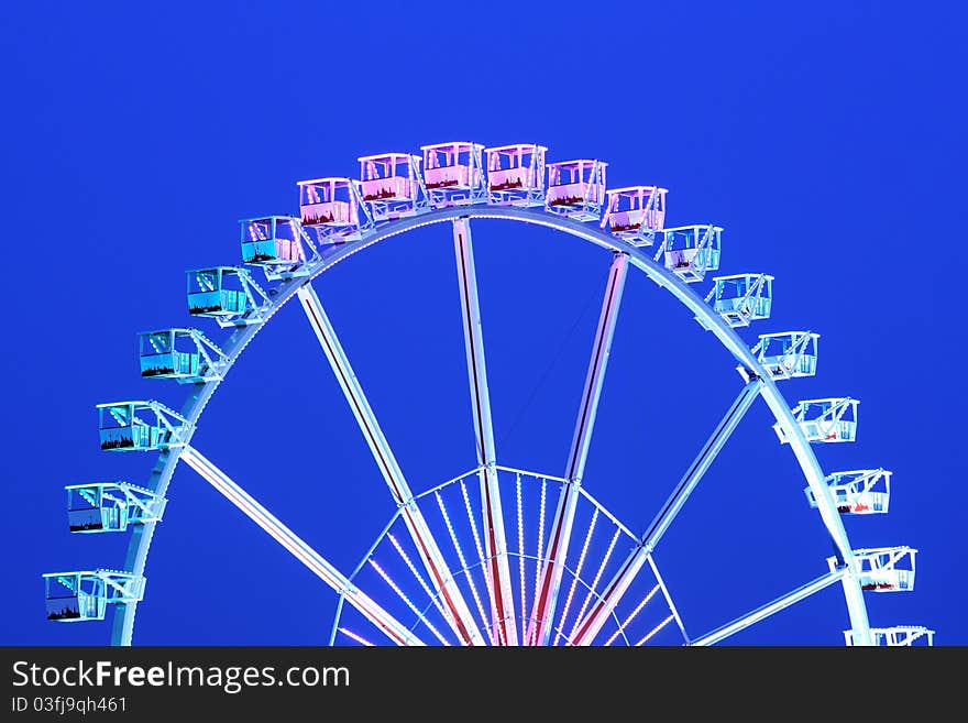 A big colorful ferris wheel and blue sky.