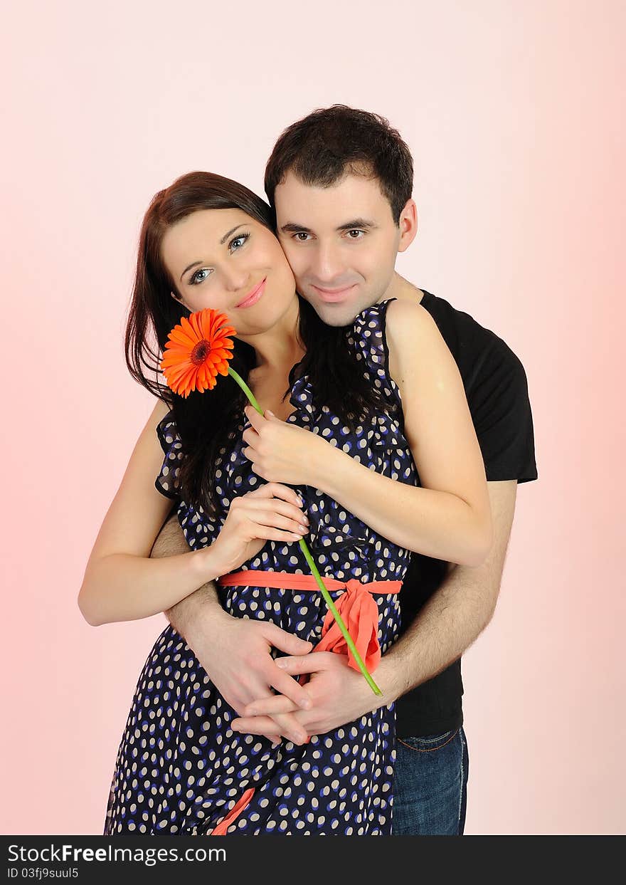 Lovely romantic man giving flower to a woman. pink background