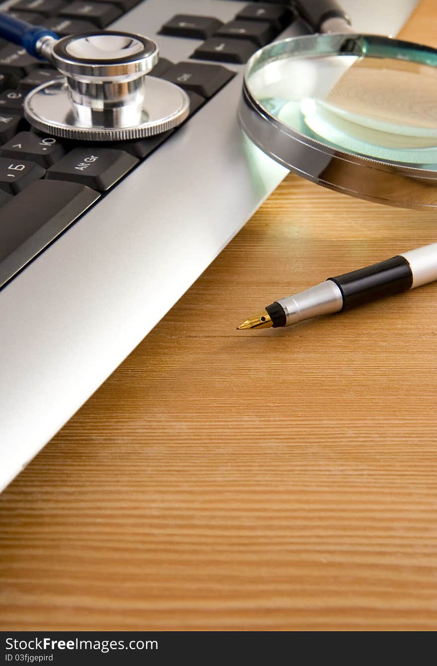 Stethoscope And Keyboard With Pen On Wood Texture