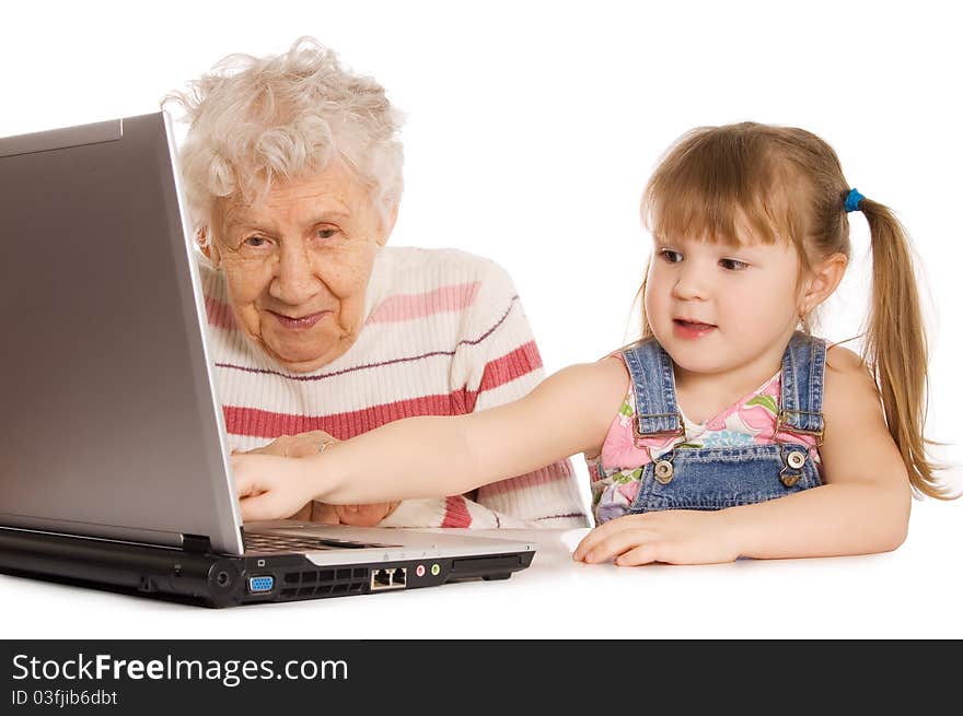 Grandmother with grand daughter at the computer in home