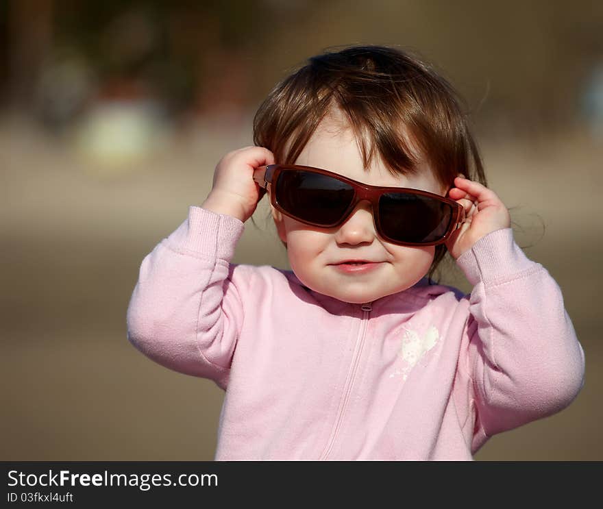 The portrait of a little girl in sunglasses. The portrait of a little girl in sunglasses