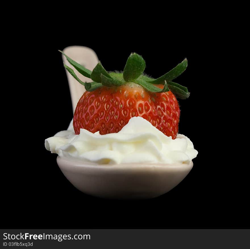 Strawberry with whipped cream. Isolated on a black background.