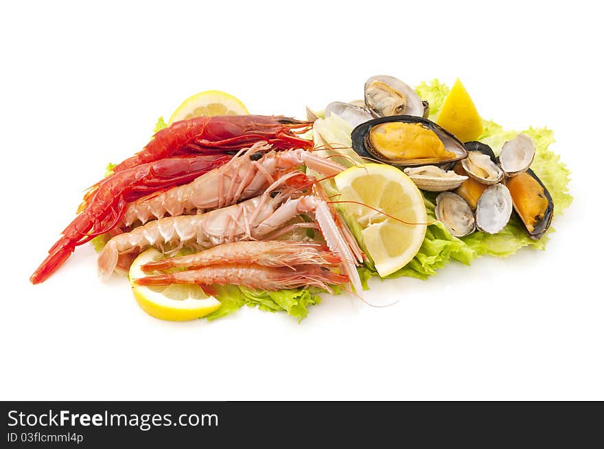 Mixed seafood over a bed of lettuce and lemon isolated on white background