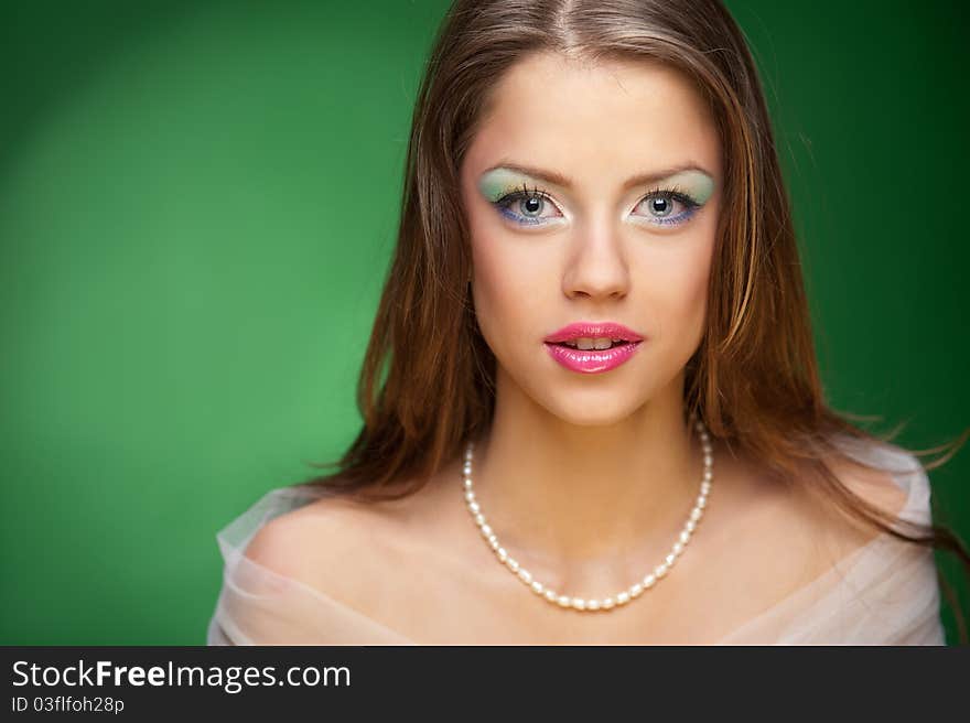 Portrait of a pretty girl on the green background