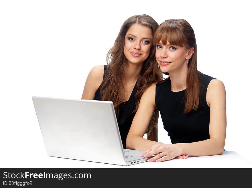 Two women working on a laptop computer.