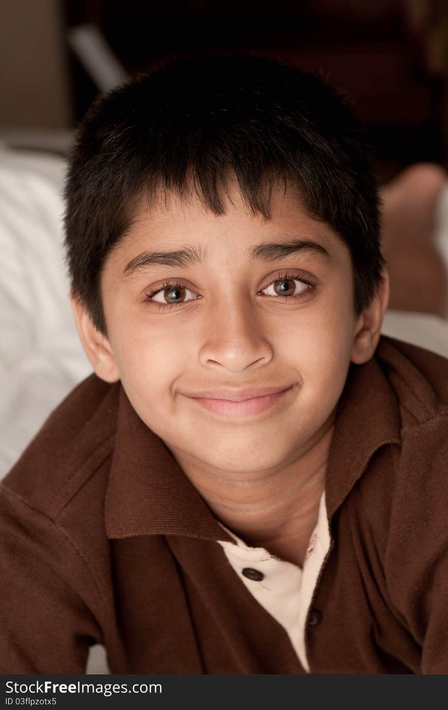 Handsome Indian kid lying happily on the bed. Handsome Indian kid lying happily on the bed