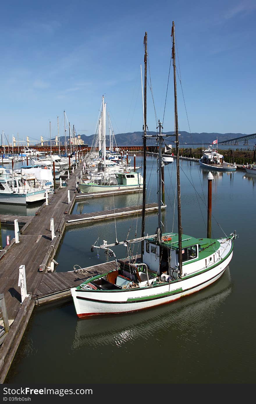 A fishing boat with outriggers raised high moored at a marina, Astoria OR. A fishing boat with outriggers raised high moored at a marina, Astoria OR.