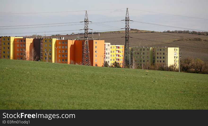 Coloured prefab houses with many windows hidden by the green field. Coloured prefab houses with many windows hidden by the green field