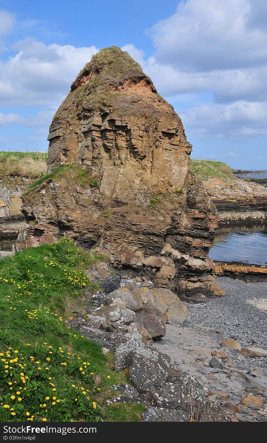 Staxigoe Rock, Staxigoe, Caithness, Scotland, UK. The rock stands by the Harbour. Staxigoe is a former fishing village, located 2 miles east of Wick on the north-eastern coast of the former county of Caithness, Scottish Highlands and is in the Scottish council area of Highland. Its name derives from Norse, &#x22;the inlet of the stack&#x22;. It was once the largest herring salting station in Europe, but its fishing industry went into decline with the construction of a larger port in central Wick. The name comes from two Norse words - &#x22;GJA&#x22; or &#x22;GOE&#x22; meaning an inlet, and &#x22;STAKKR&#x22; meaning a rock or stack, hence &#x22;Staxigoe&#x22;, the inlet of the stack. At the end of the 18th and the beginning of the 19th century, a few unscrupulous landlords began evicting tenants from land which had been theirs since the times of the clan system. Sheep had arrived in the Highlands, and the &#x22;Highland Clearances&#x22; began. Men were sent to war out of loyalty to their chief, and those who returned found their homes and crofts burned and their families scattered to the four corners of the earth. Those who were left - women, children, and the old people - had to walk the 100 miles or more from the hills and straths of Sutherland to the bleak and barren coasts to try to find settlements and a means of living. The growth in the population of Staxigoe, Wick and many hamlets and villages along the coast resulted in the birth of herring fishing. Inexperienced men