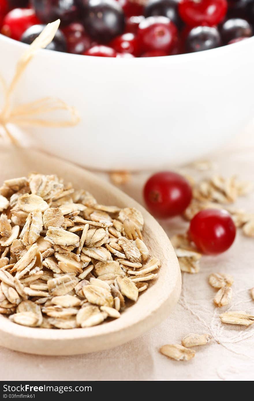 Healthy oat flakes on a wooden spoon and berries. Healthy oat flakes on a wooden spoon and berries.